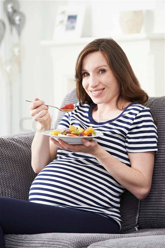Pregnant Woman Eating Healthy Fruit Salad, stock photo