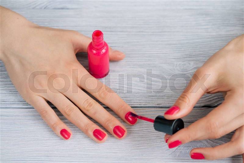 Female hands painted nails with red lacquer, close-up, stock photo