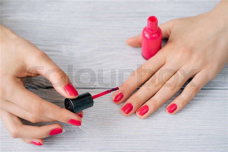 Female hands painted nails with red lacquer, stock photo