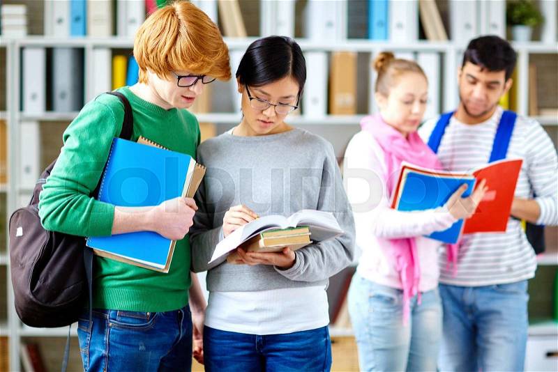 Clever students reading books in library, stock photo