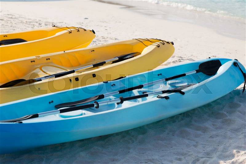 Kayaking, leisure, water sport and summer vacations concept - canoes or kayaks on sandy beach, stock photo