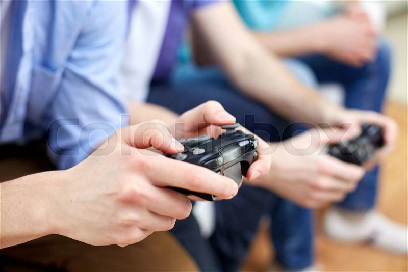 Friendship, technology, games and home concept - close up of male friends playing video games at home, stock photo