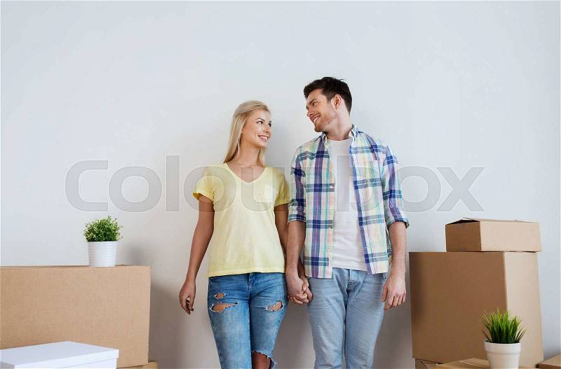 Home, people, repair and real estate concept - smiling couple with big cardboard boxes moving to new place, stock photo