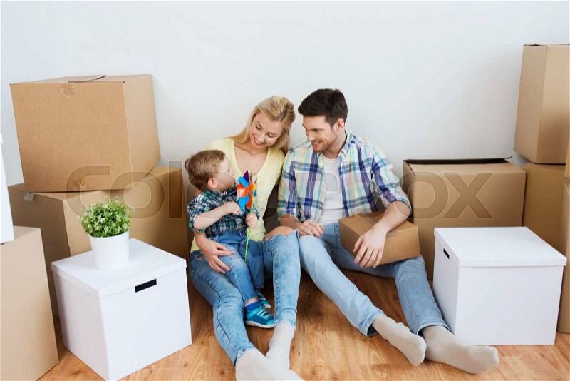 Mortgage, people, housing and real estate concept - happy family with boxes moving to new home, stock photo