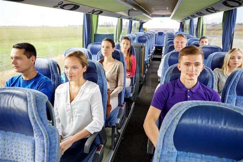 Transport, tourism, road trip and people concept - group of passengers or tourists in travel bus, stock photo