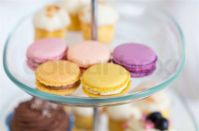 Unhealthy eating, sweets, dessert, baking and junk food concept - close up of cake stand with macaroon cookies, stock photo