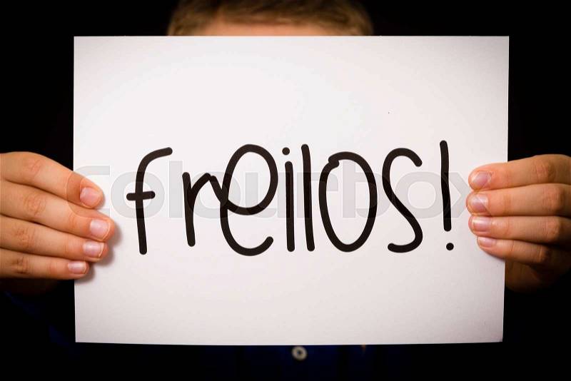 Studio shot of child holding a sign with German word Freilos - See You Later, stock photo