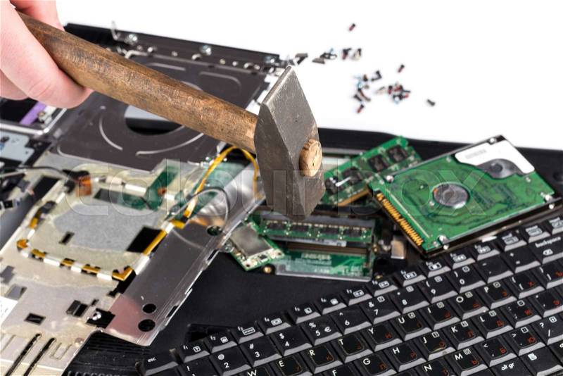 Destroying laptop computer parts with a hammer, stock photo