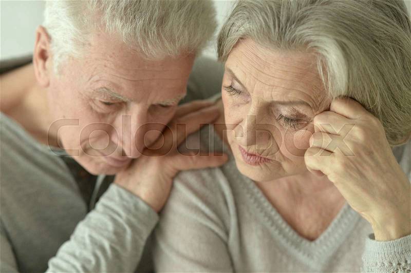 Portrait of a sad mature couple in the room, stock photo