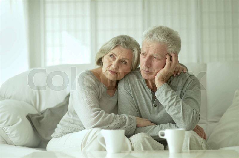 Sad Mature couple with cups in the room, stock photo
