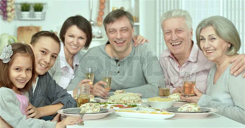 Portrait of happy family at the table with tasty food, stock photo