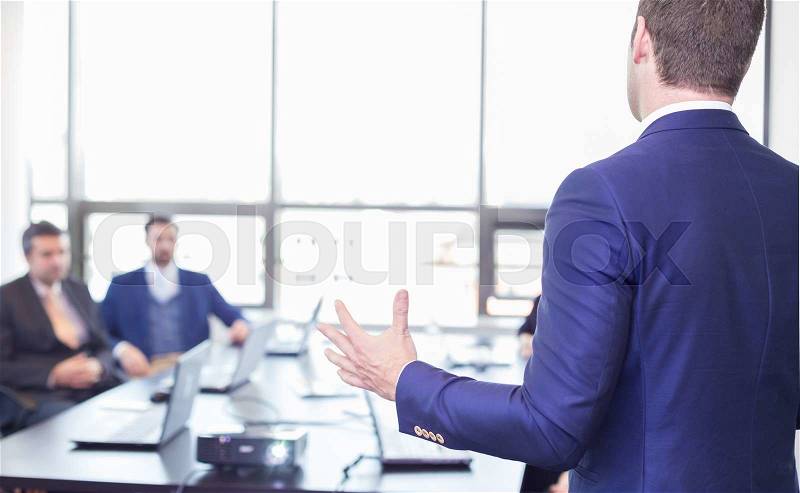 Business man making a presentation in office. Business executive delivering a presentation to his colleagues during meeting or in-house business training, explaining business plans to his employees. , stock photo
