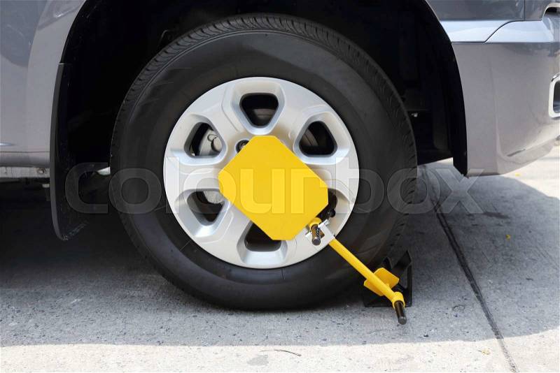 Clamped front wheel with yellow wheel lock, stock photo