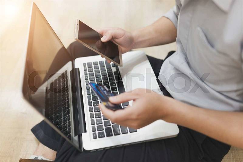 Man is holding a credit card and using pc or laptop for online shopping , stock photo
