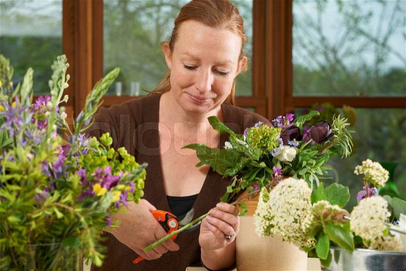 Florist Working On Arrangement In Flower Shop, stock photo