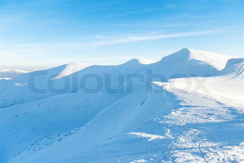 Beautiful winter landscape with snow mountains under blue sky, stock photo