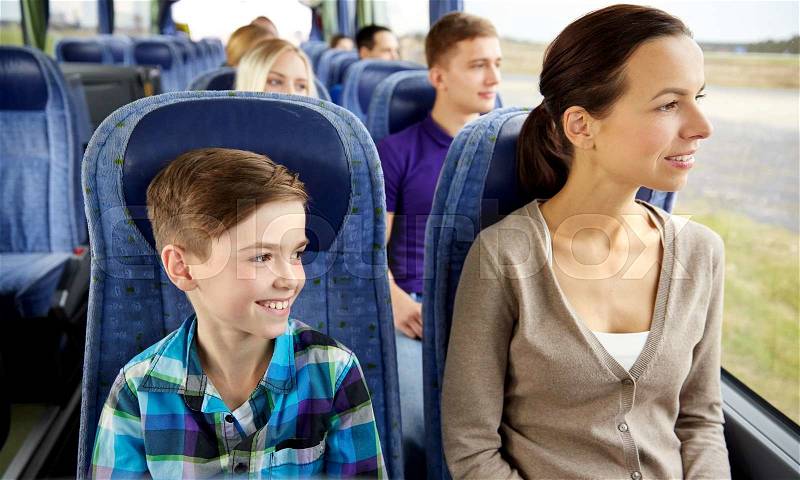 Travel, tourism, family, technology and people concept - happy mother and son riding in travel bus, stock photo