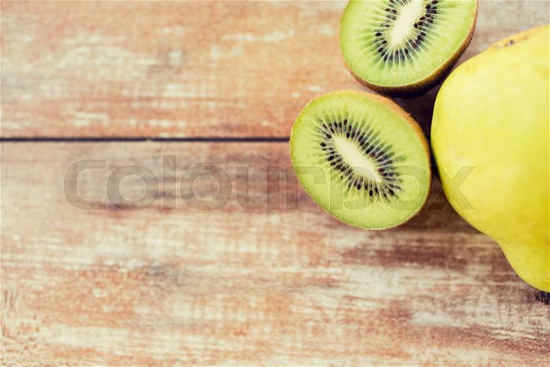 Fruits, diet, food and objects concept - close up of ripe kiwi and pear on table, stock photo