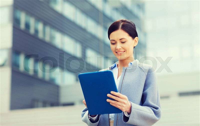 Business, technology and people concept - young smiling woman with tablet pc computer over office building, stock photo