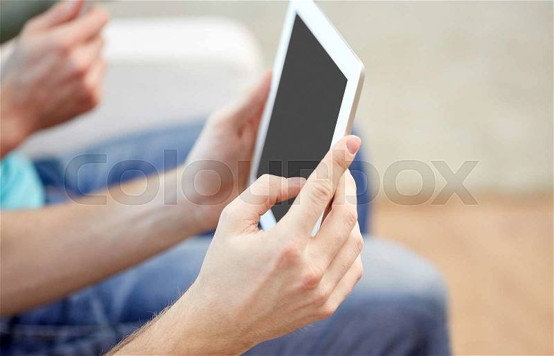 Technology and people concept - close up of male hands with tablet pc computer blank screen at home, stock photo