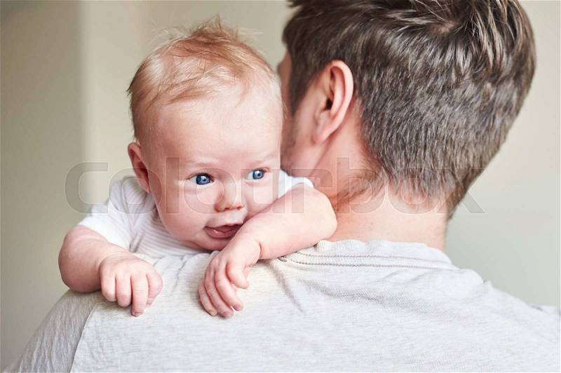 Happy father holding newborn baby in his arms, stock photo