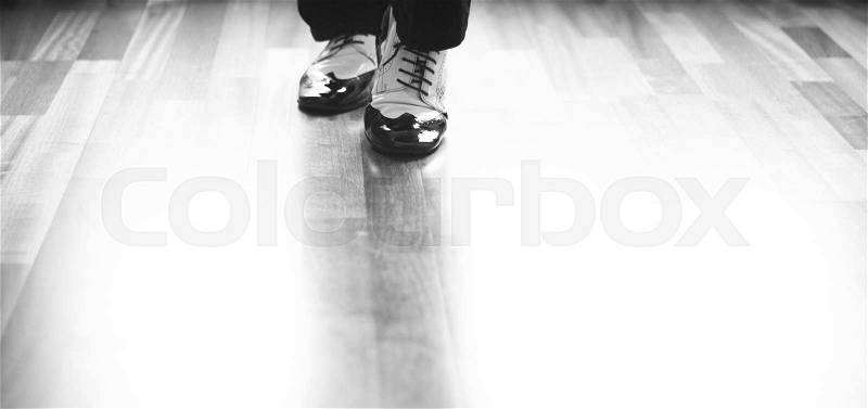 Male ballroom, standard, sport dance, latin and salsa dancer feet and shoes in dance academy school rehearsal room dancing salsa, stock photo