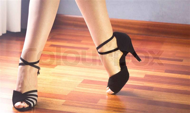 Female ballroom, standard, sport dance, latin and salsa dancer feet and shoes in dance academy school rehearsal room dancing salsa, stock photo