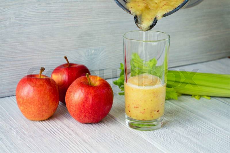 Smoothies made from apples and celery is poured into a glass from a food processor. Concept of healthy eating, stock photo