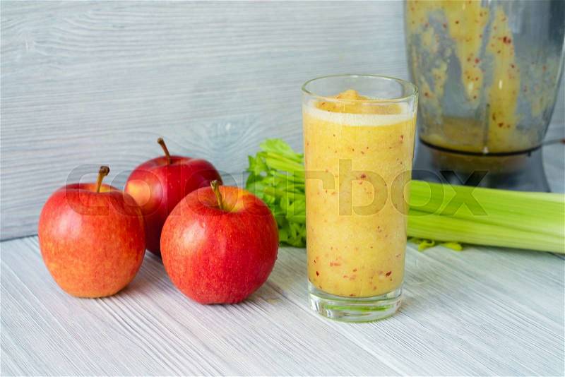 Smoothies made from apples and celery in a glass on a table near the food processor, stock photo