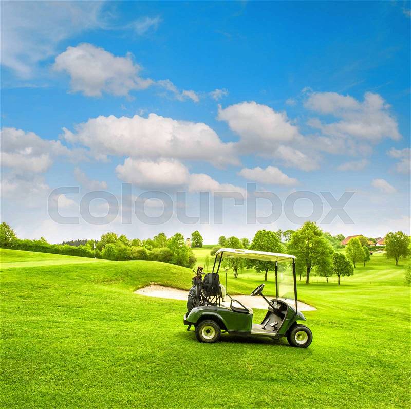 Green golf course field and cloudy blue sky. Spring landscape with fresh grass. Vibrant colors, stock photo