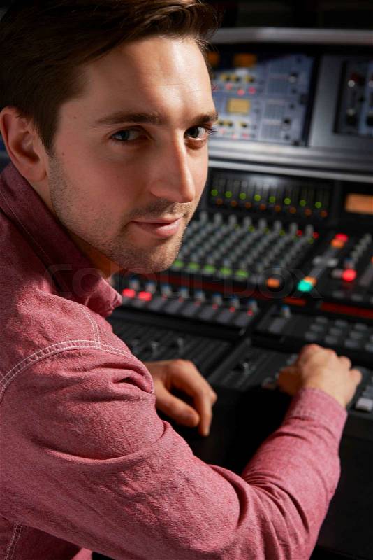 Engineeer Working At Mixing Desk In Recording Studio, stock photo