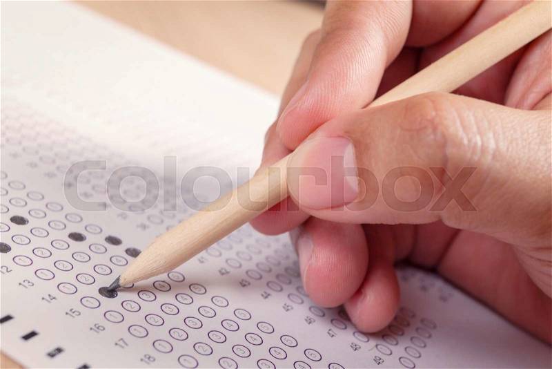 Hand fill in Exam carbon paper computer sheet and pencil, stock photo