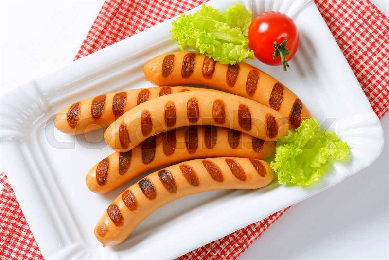 Grilled Vienna sausages on white porcelain plate, stock photo