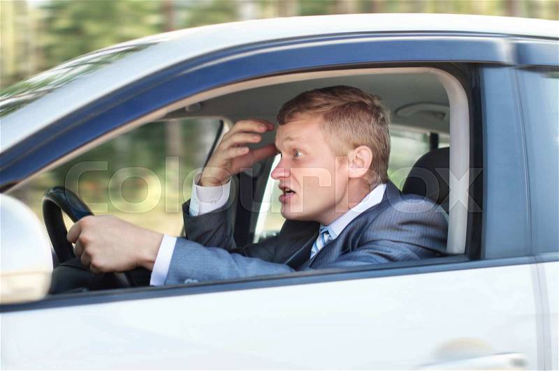 Aggressive driver behind the wheel of a car, stock photo