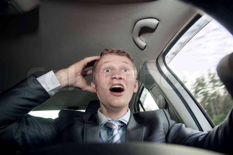 Scared, the driver behind the wheel of of the car, stock photo