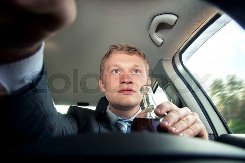 Drinking and driving a car while driving, stock photo
