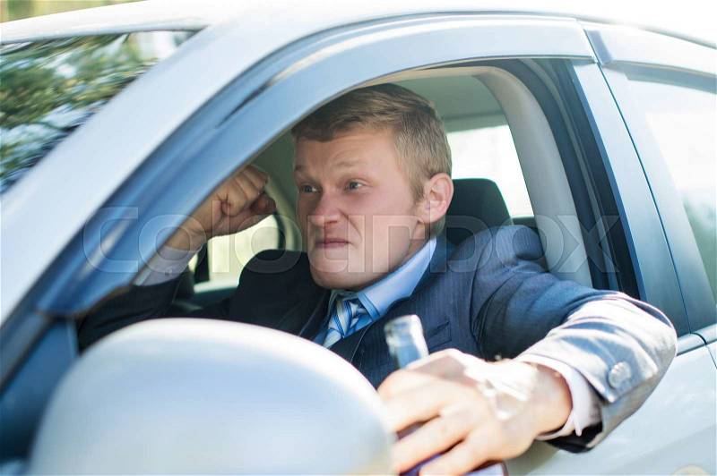 Aggressive drunk driver behind the wheel of of the car, stock photo