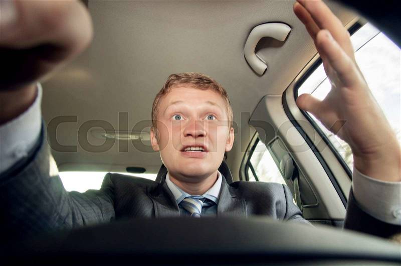 Aggressive driver behind the wheel of a car while driving, stock photo
