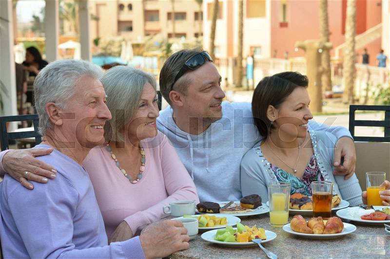 Happy family at breakfast on tropical resort, stock photo