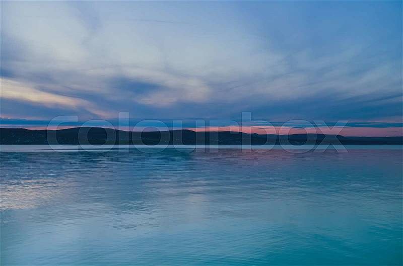 Evening view of the lake and mountains at sunset, blue hour. Balaton, Hungary, stock photo