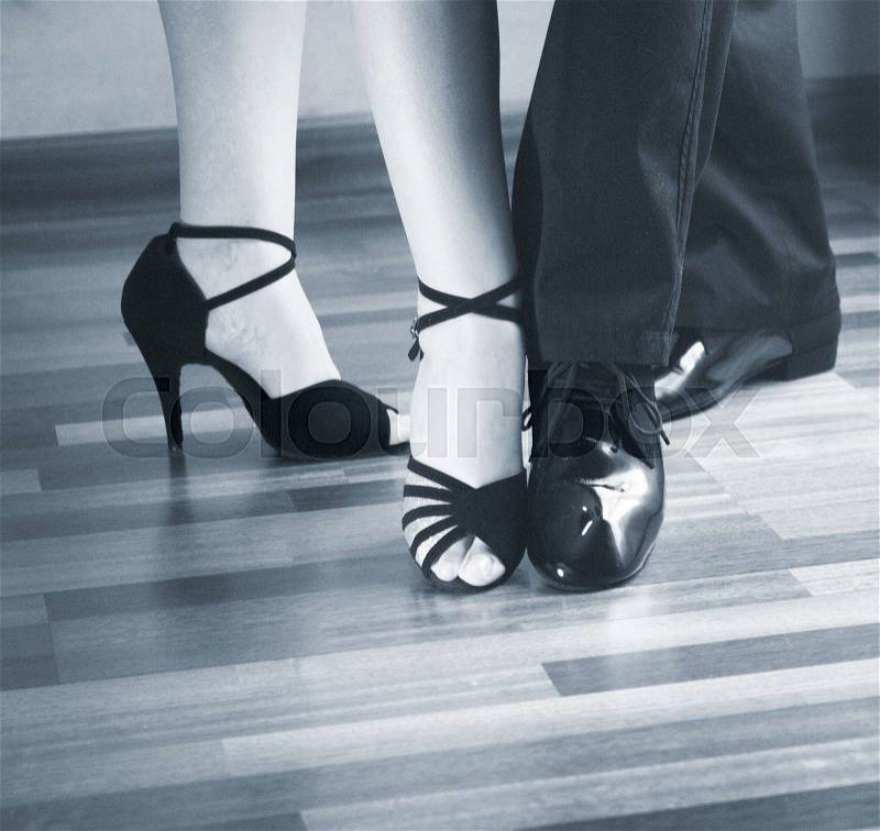 Male and female ballroom, standard, sport dance, latin and salsa couple dancers feet and shoes in dance academy school rehearsal room dancing modern contemporary style, stock photo