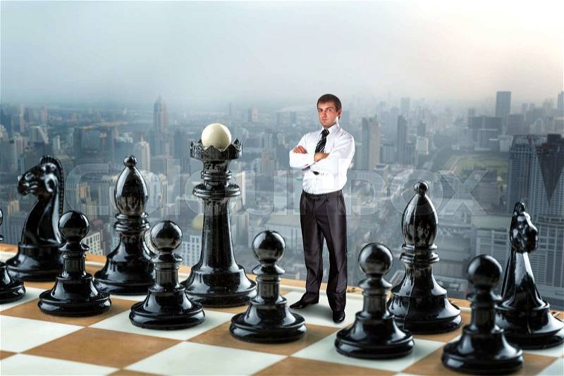 Businessman standing instead of king in the black team on the chess board , stock photo