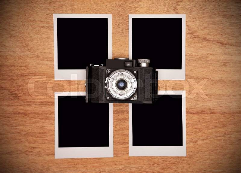 Vintage camera with four blank photo card on wooden table, stock photo