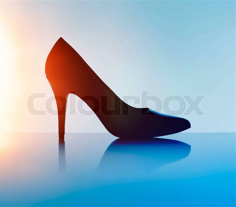 Women\'s black pump shoe in silhouette and with lens flare, stock photo
