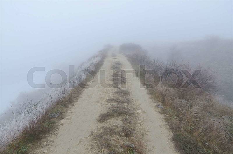 Dirty road to horizon in fog, stock photo