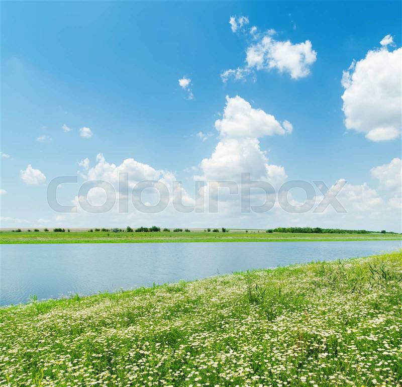River in green grass and white clouds over it, stock photo