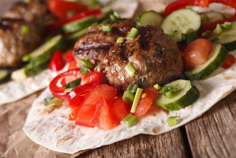Meatballs with fresh vegetables on a tortilla close-up on the table. horizontal , stock photo