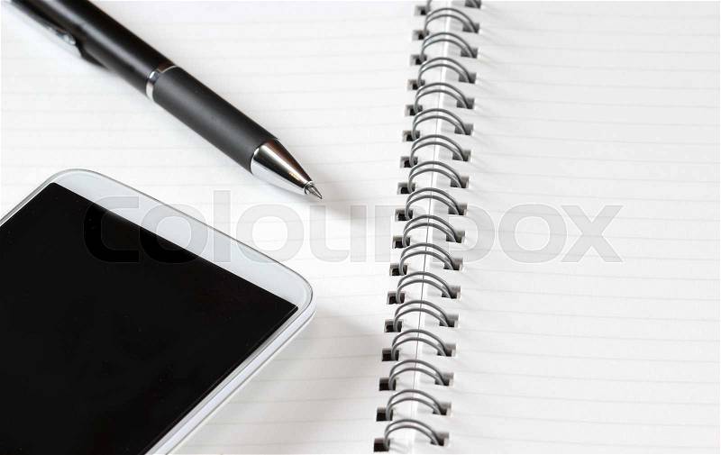 Close up shot of hand held calculator, silver pen and notepad in horizontal layout, stock photo