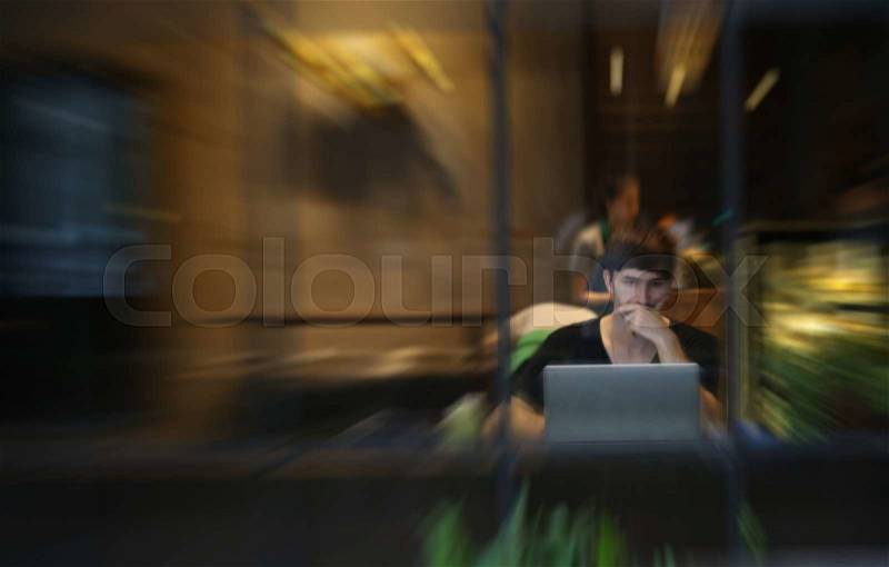 Blurred man use computer in cafe, stock photo