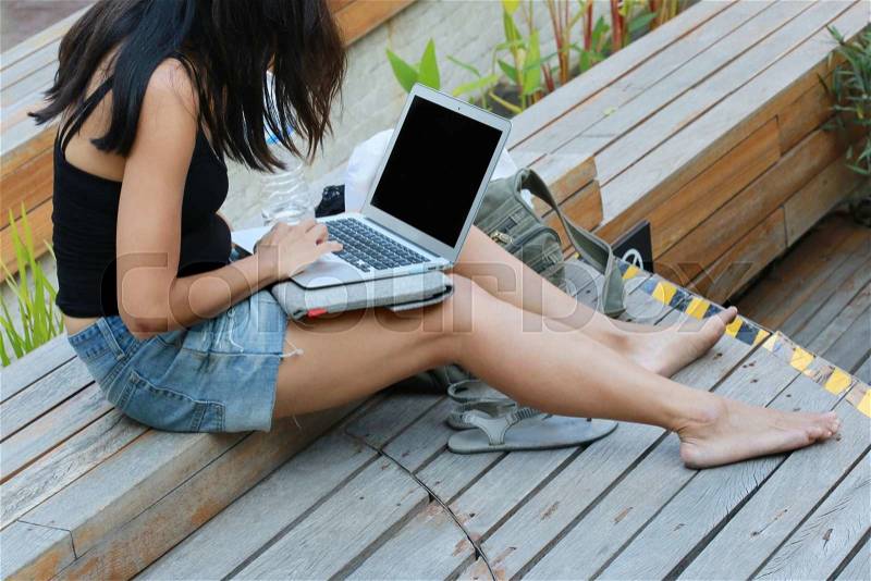 Women using laptop in outdoor park, stock photo